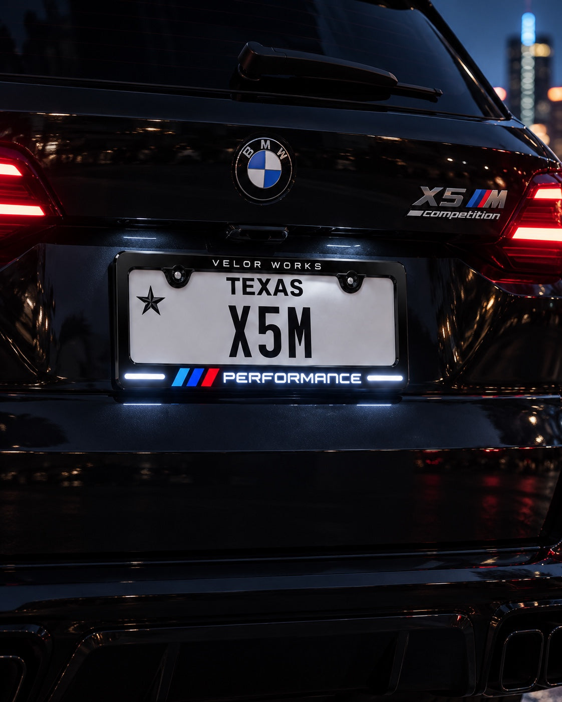 Velor Works Design B illuminated PERFORMANCE license plate frame on black BMW X5 M at night