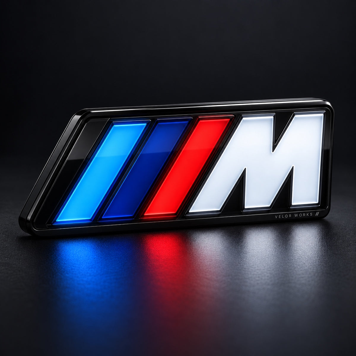 Velor Works universal illuminated M emblem glowing on dark background