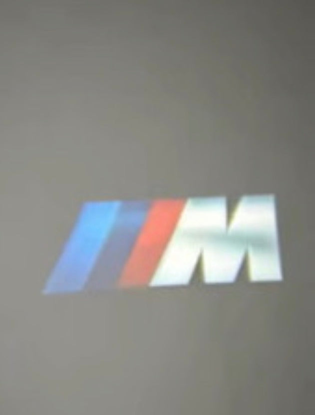 USB logo projector showing the compact Signature projection on a dark wall